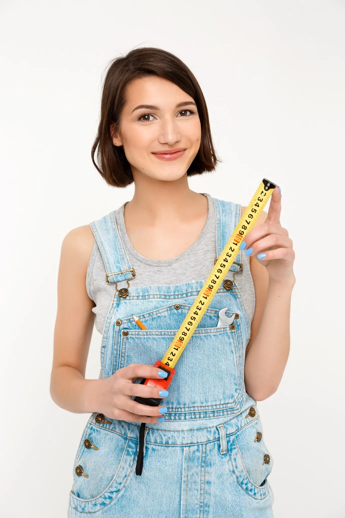 Mujer constructora inteligente y feliz, sosteniendo una cinta métrica.